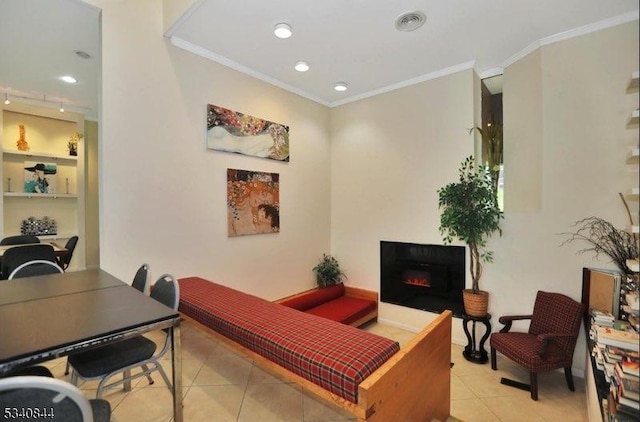 interior space with ornamental molding, a lit fireplace, and built in shelves