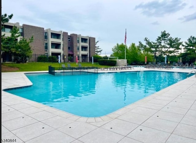 pool with a patio and fence