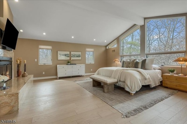 bedroom featuring baseboards, beam ceiling, recessed lighting, wood finished floors, and a glass covered fireplace