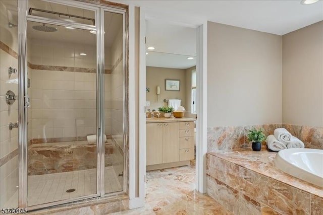 bathroom featuring vanity, a bath, and a stall shower