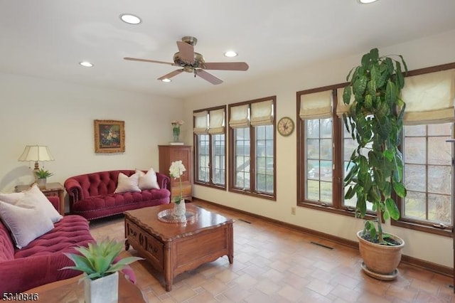 living area featuring baseboards, a healthy amount of sunlight, visible vents, and recessed lighting