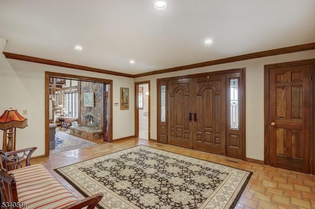 entryway with recessed lighting, crown molding, and baseboards