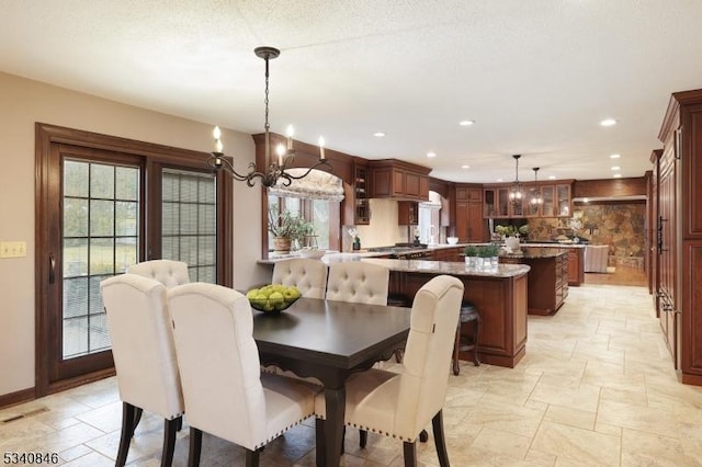 dining room with recessed lighting, stone tile flooring, visible vents, and a notable chandelier