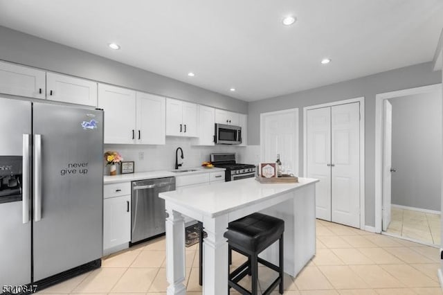 kitchen featuring white cabinetry, appliances with stainless steel finishes, light countertops, and a sink