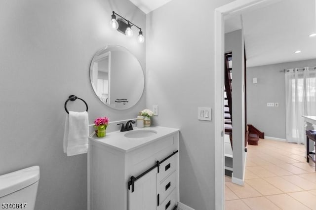 bathroom featuring recessed lighting, toilet, vanity, baseboards, and tile patterned floors