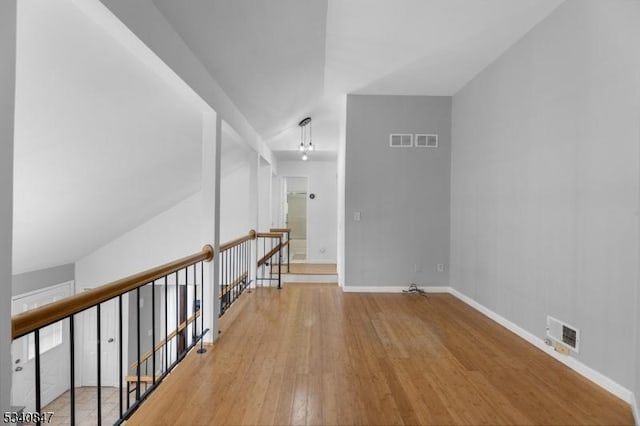 unfurnished room featuring hardwood / wood-style flooring, visible vents, and baseboards