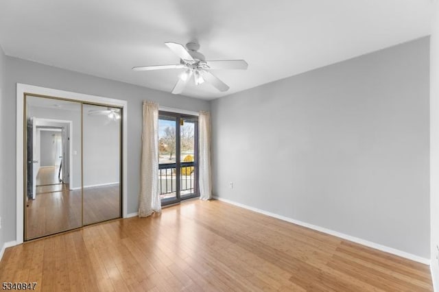 unfurnished bedroom featuring access to exterior, a closet, baseboards, and light wood-style floors