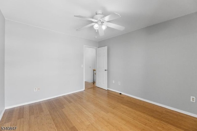 unfurnished room featuring light wood finished floors, a ceiling fan, and baseboards