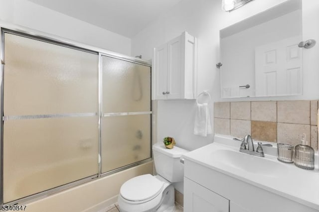 bathroom featuring toilet, tasteful backsplash, bath / shower combo with glass door, and vanity