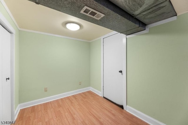 interior space featuring ornamental molding, visible vents, baseboards, and wood finished floors