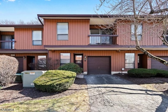 townhome / multi-family property featuring aphalt driveway, a balcony, and a garage