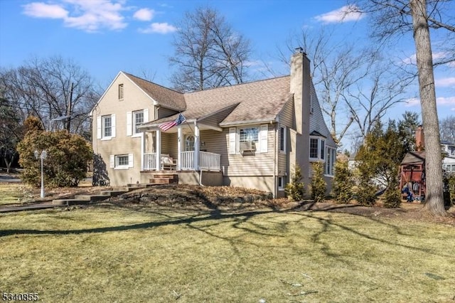 view of front facade with a shingled roof, a front yard, a playground, and a chimney