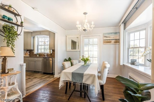 dining area with dark wood-style flooring, baseboards, and an inviting chandelier