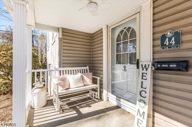 view of exterior entry featuring covered porch and ceiling fan