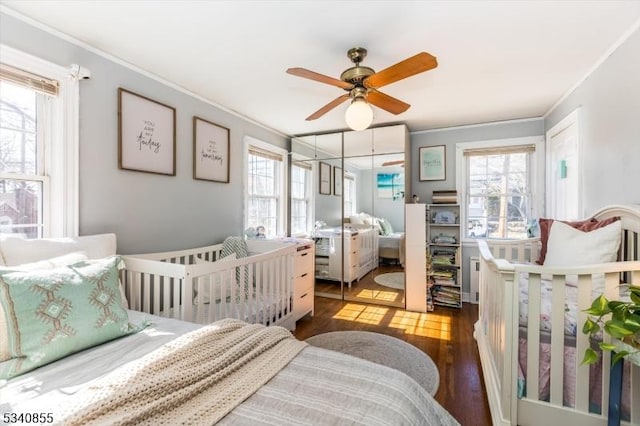 bedroom featuring multiple windows, crown molding, and wood finished floors