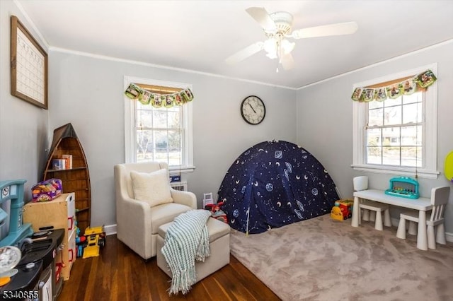 interior space with wood finished floors, a ceiling fan, and crown molding