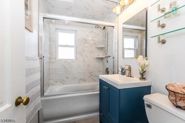 full bathroom featuring enclosed tub / shower combo, vanity, toilet, and a healthy amount of sunlight