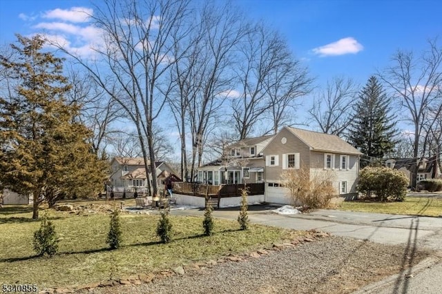 view of side of property featuring a garage, concrete driveway, and a lawn