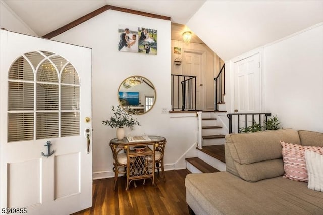 foyer with wood finished floors, vaulted ceiling, baseboards, and stairs