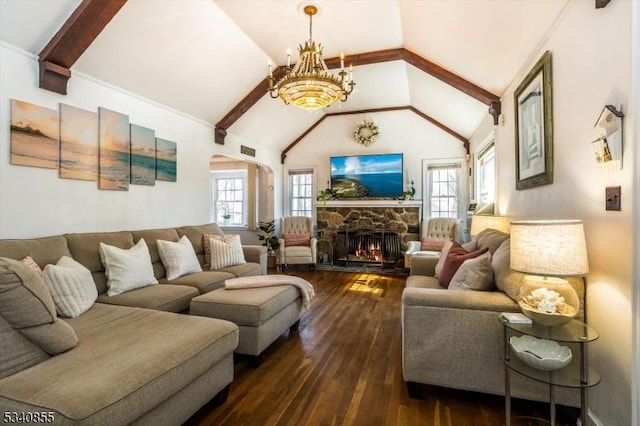 living room featuring dark wood-style flooring, a notable chandelier, a stone fireplace, and beamed ceiling