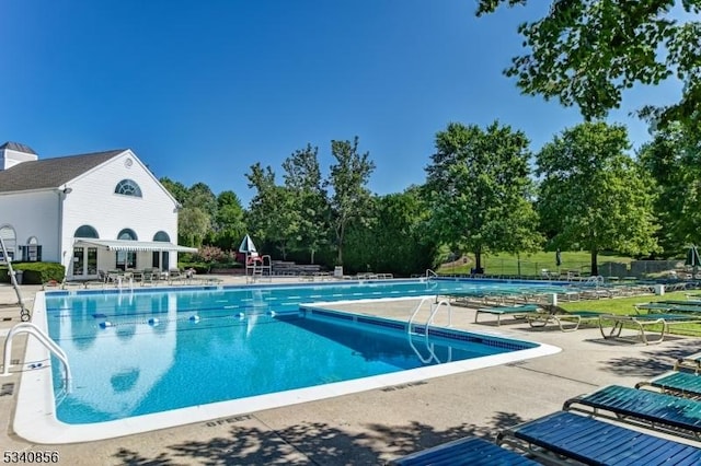 pool with a patio area and fence