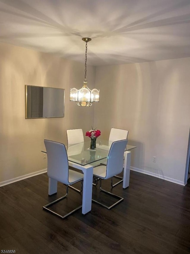 dining room with dark wood-style floors, a notable chandelier, and baseboards