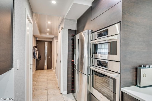 kitchen featuring light tile patterned floors, recessed lighting, stainless steel appliances, baseboards, and light countertops