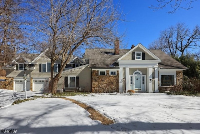 view of front of property featuring a garage, stone siding, and a chimney