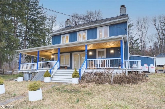 view of front facade with covered porch and a chimney