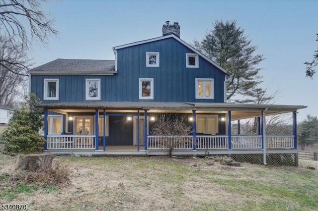 rear view of house featuring covered porch, a chimney, and board and batten siding