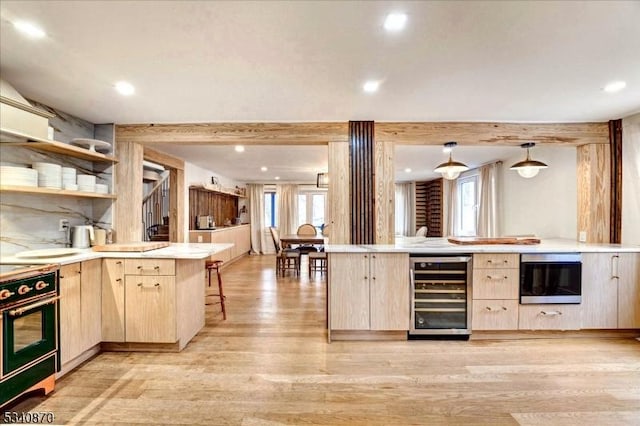 kitchen with beverage cooler, a peninsula, light brown cabinets, and black electric range oven