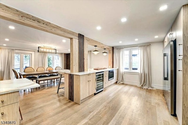 kitchen featuring beverage cooler, light wood-type flooring, light brown cabinets, and modern cabinets