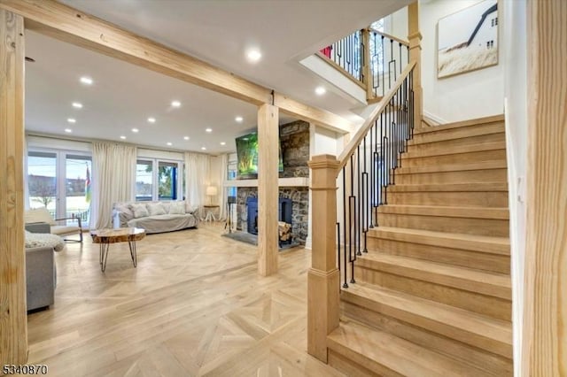 staircase featuring recessed lighting and a stone fireplace