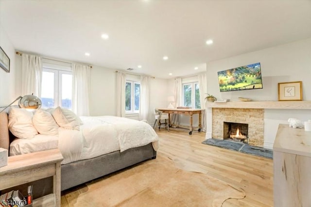 bedroom with a fireplace, wood finished floors, and recessed lighting