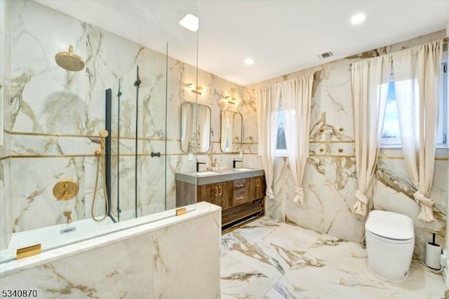 bathroom featuring a marble finish shower, marble finish floor, vanity, a healthy amount of sunlight, and stone wall