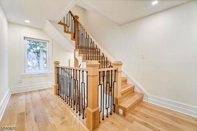 staircase featuring wood finished floors and baseboards