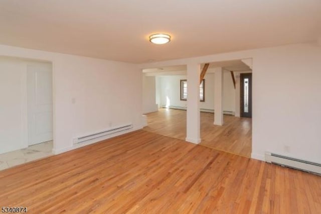 spare room with a baseboard radiator, a baseboard heating unit, and light wood-style flooring