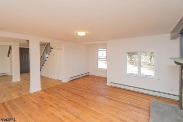 unfurnished living room featuring light wood-style flooring, stairway, and baseboard heating