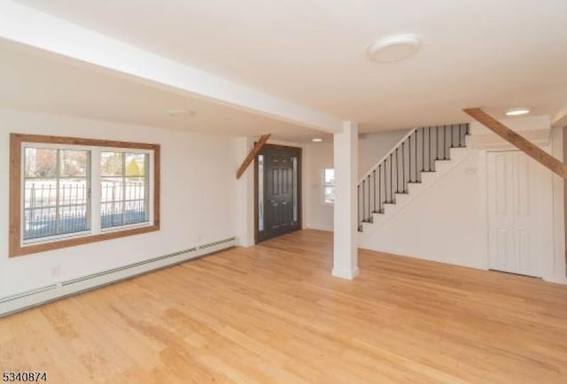 entryway with stairway, a baseboard radiator, and wood finished floors