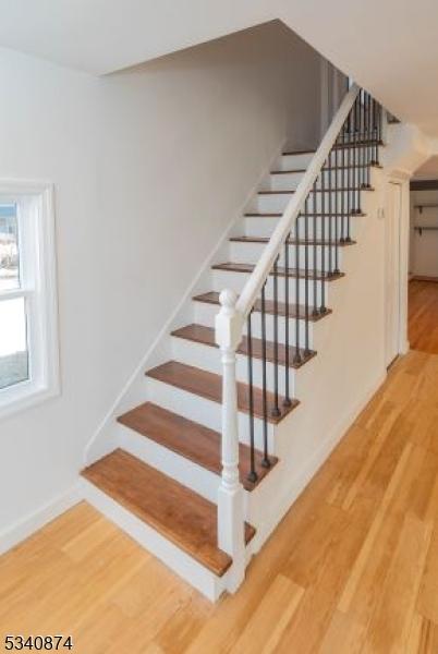 stairway featuring baseboards and wood finished floors