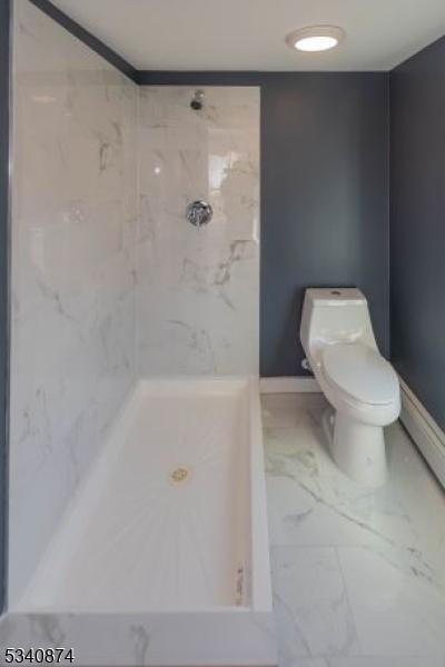 full bath with marble finish floor, baseboards, a shower stall, and toilet