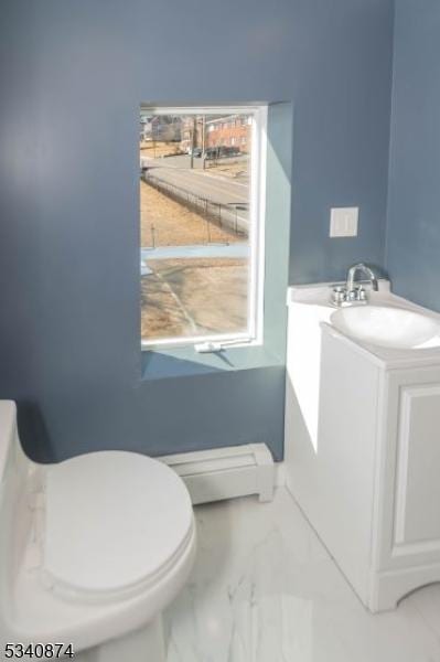 half bathroom with toilet, marble finish floor, and vanity