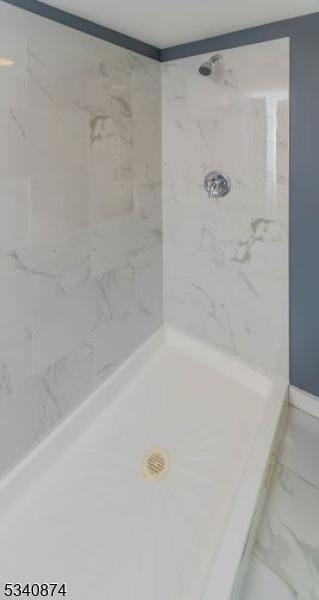 bathroom featuring marble finish floor and a marble finish shower