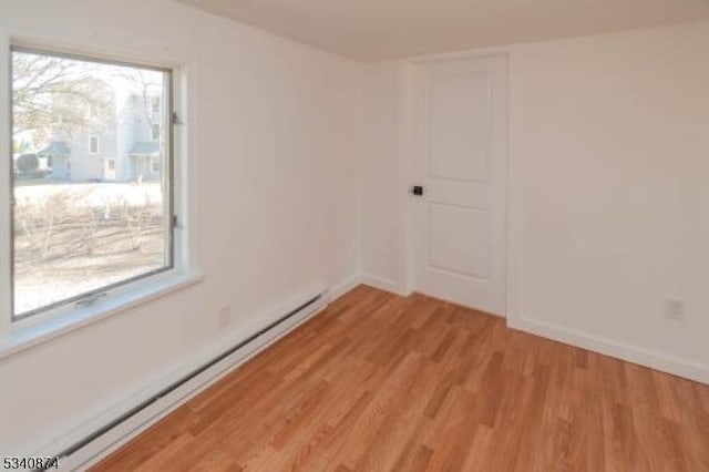 spare room with light wood-style floors, baseboards, and baseboard heating