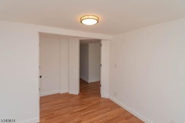 empty room with baseboards and light wood finished floors