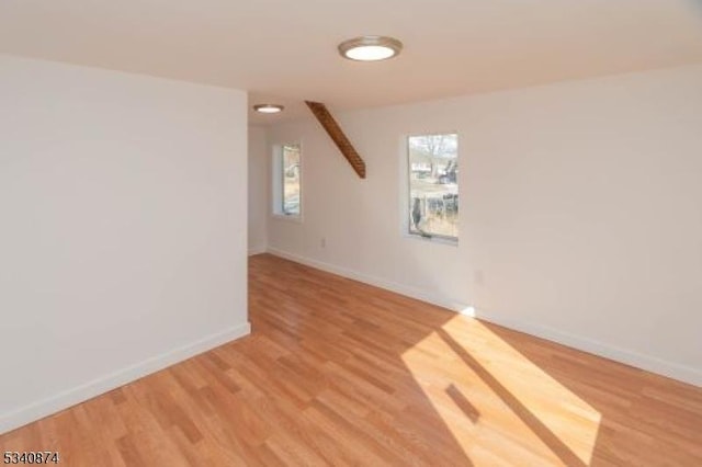 bonus room featuring light wood-type flooring and baseboards