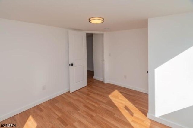 spare room with light wood-type flooring and baseboards