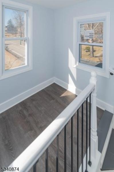 stairway featuring wood finished floors and baseboards