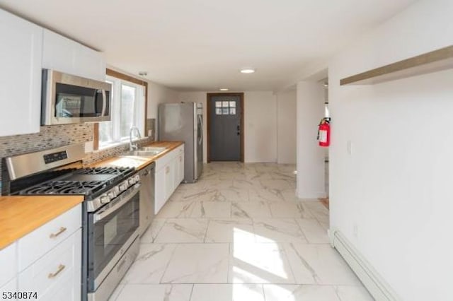 kitchen featuring stainless steel appliances, marble finish floor, white cabinetry, and tasteful backsplash