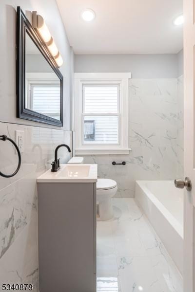 full bath with tile walls, marble finish floor, vanity, and toilet